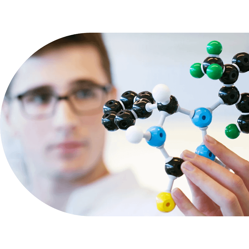 Organic chemist 800x800 px A person wearing glasses holds and examines a colorful molecular model, highlighting the intricate work of an organic chemist and offering insight into potential chemistry careers.